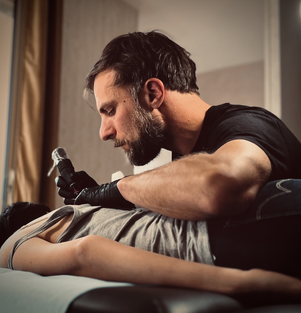 Alex Saman, tatoueur à Saumur, en train de réaliser un tatouage dans son studio.