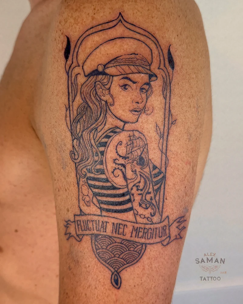 Tatouage d’une femme portant une casquette de marin, dans un cadre ornemental avec une inscription.