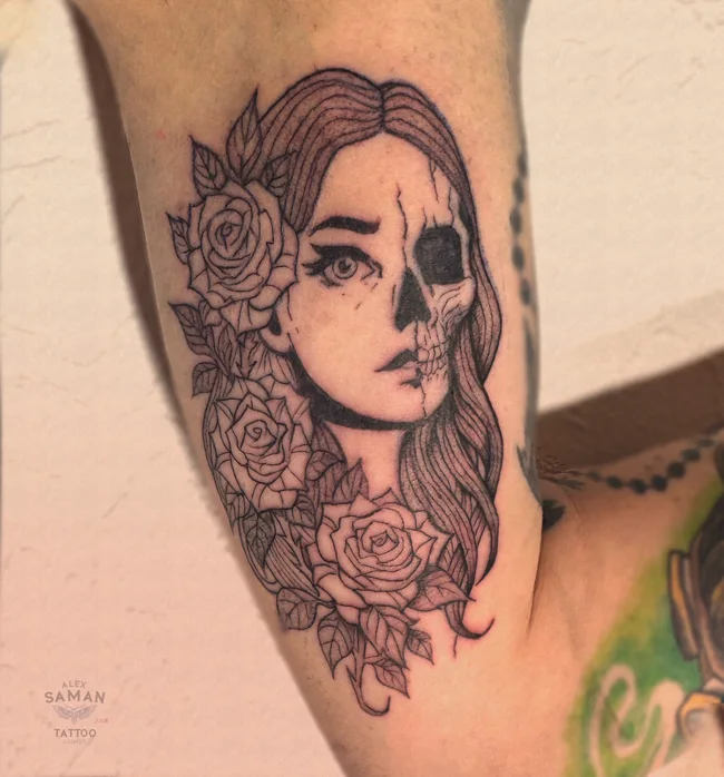 Tatouage d’un portrait féminin dont une moitié du visage révèle un crâne, entouré de roses.