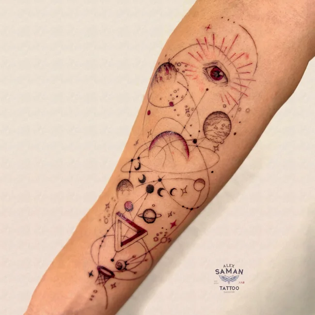 Tatouage composé d’un soleil, de lunes et de figures géométriques sur l’avant-bras.
